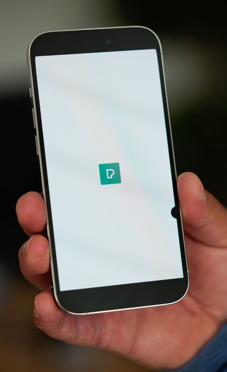 A phone-snapped screenshot of a mobile banking app showing a recent $5,000 direct deposit from a partner platform, imperfect angle, screen is the sole subject
